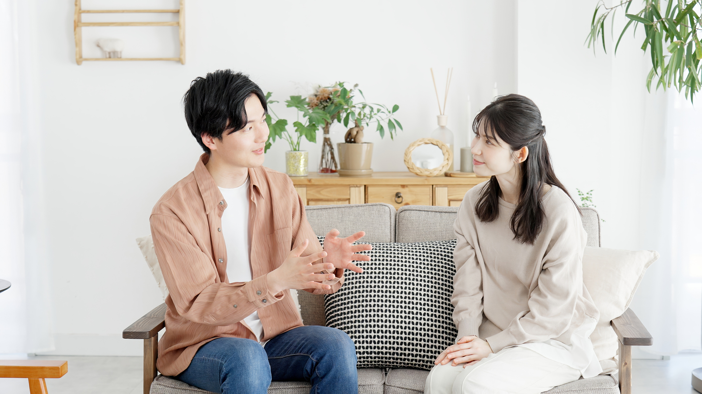 リビングで仲良く、納得するまで話し合う夫婦の画像。